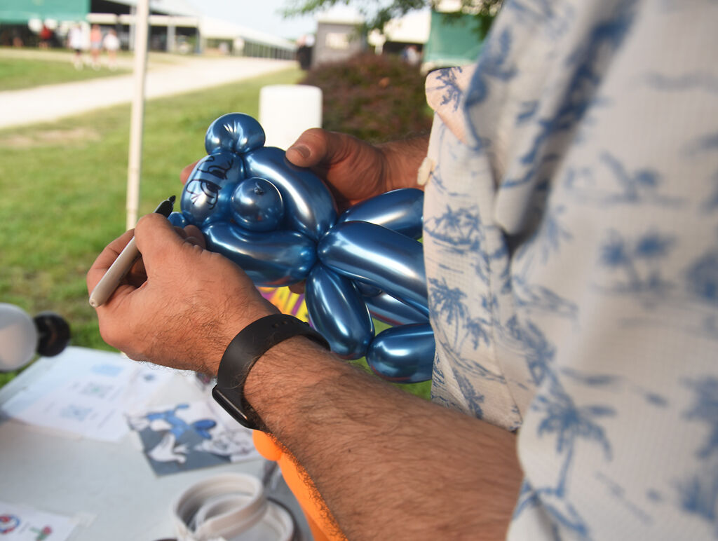 Dale Campbell makes a balloon bear for a child